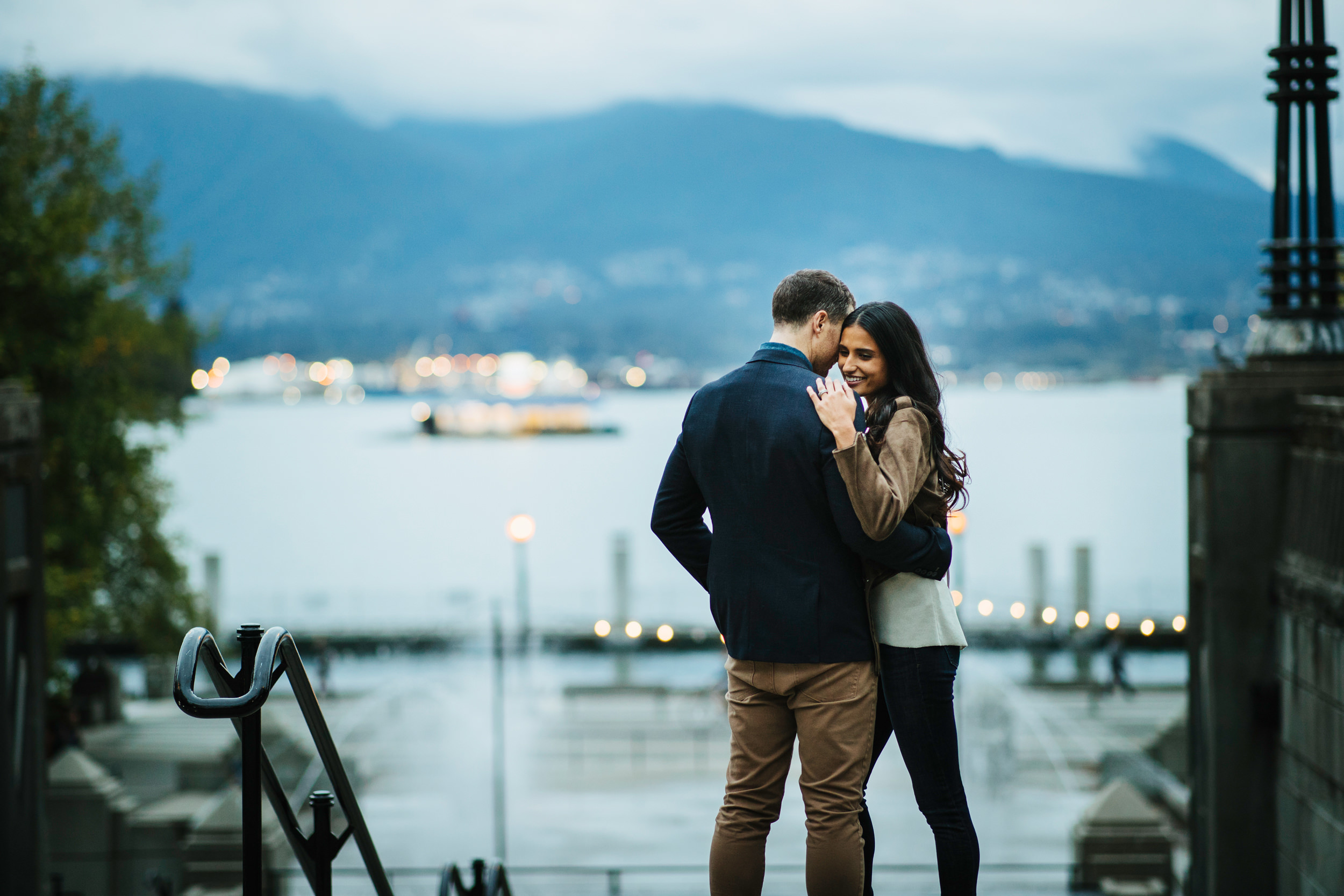 couple embrace with a blurred background of the bowardwalk