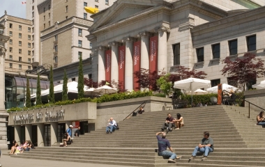outside view of vancouver art gallery witg many people sitting on the stairs