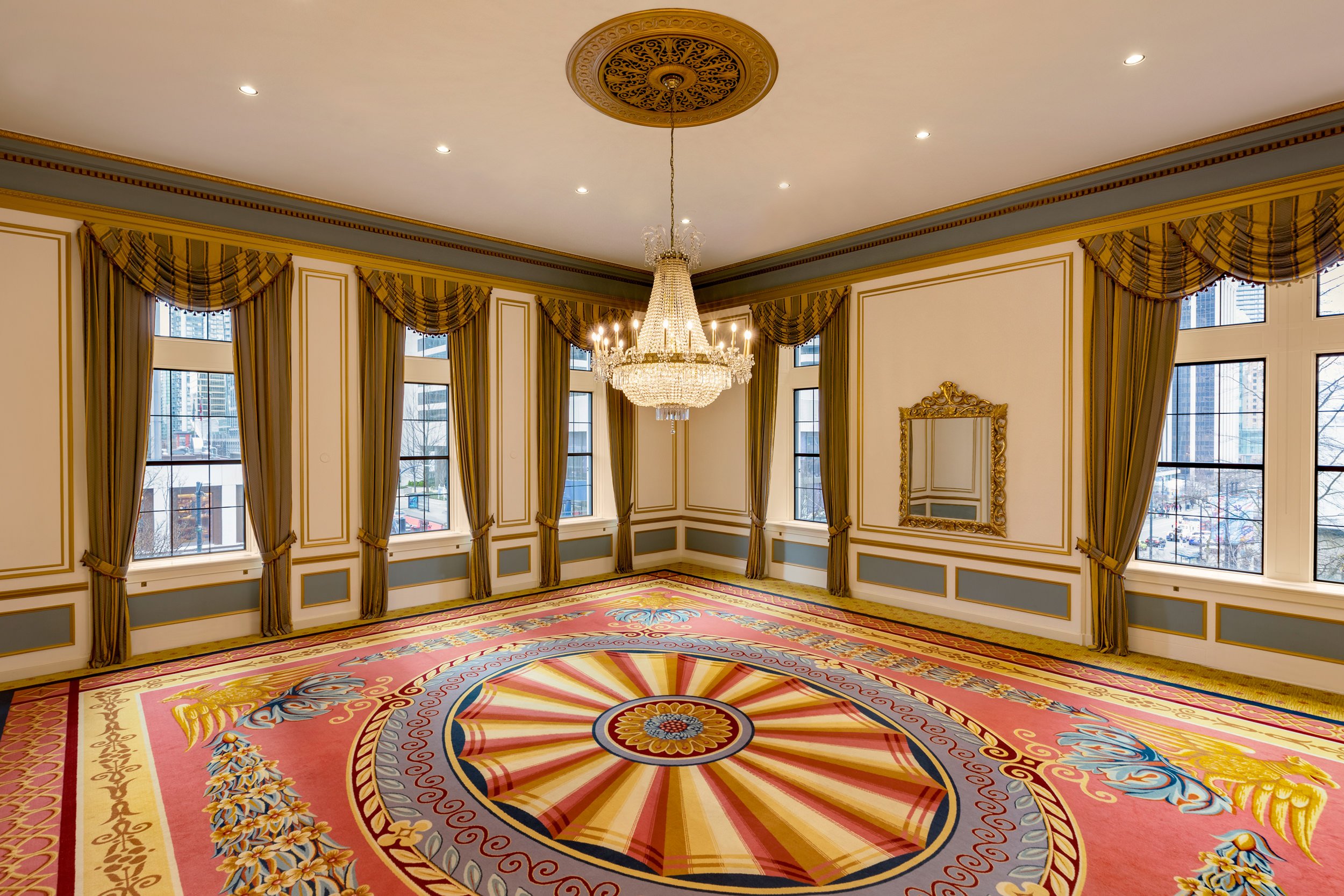 large room with a chandelier hanging from the center of the ceiling