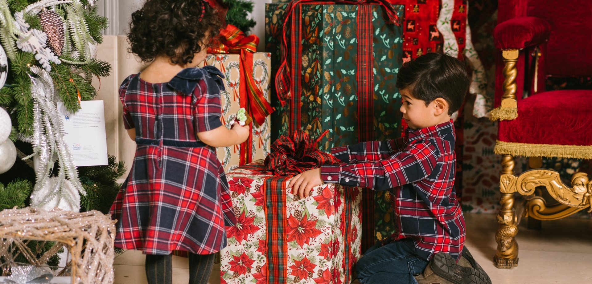 Kids in festive outfits looking at beautifully-wrapped gifts at Fairmont Hotel Vancouver