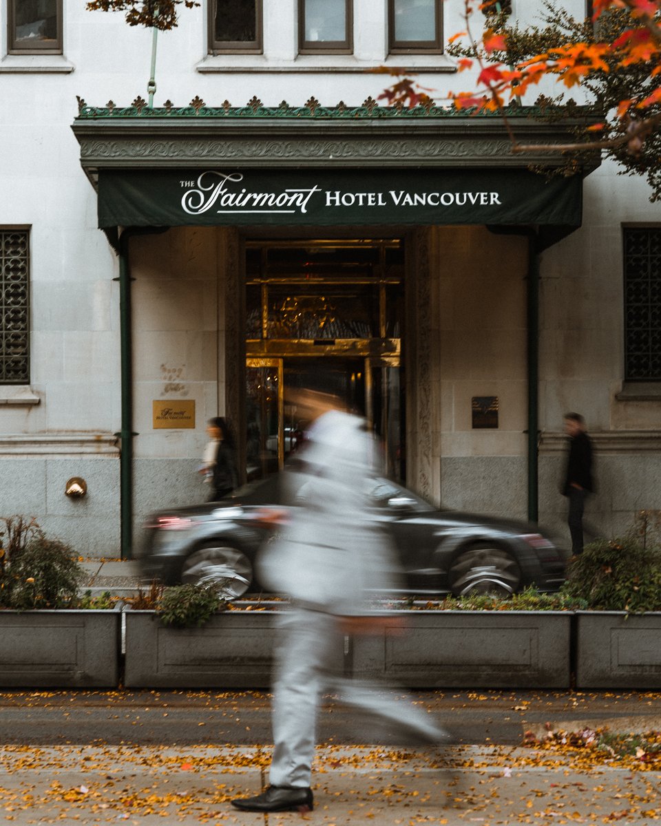 View of blurry person walking in autumn in front of Fairmont Hotel Vancouver