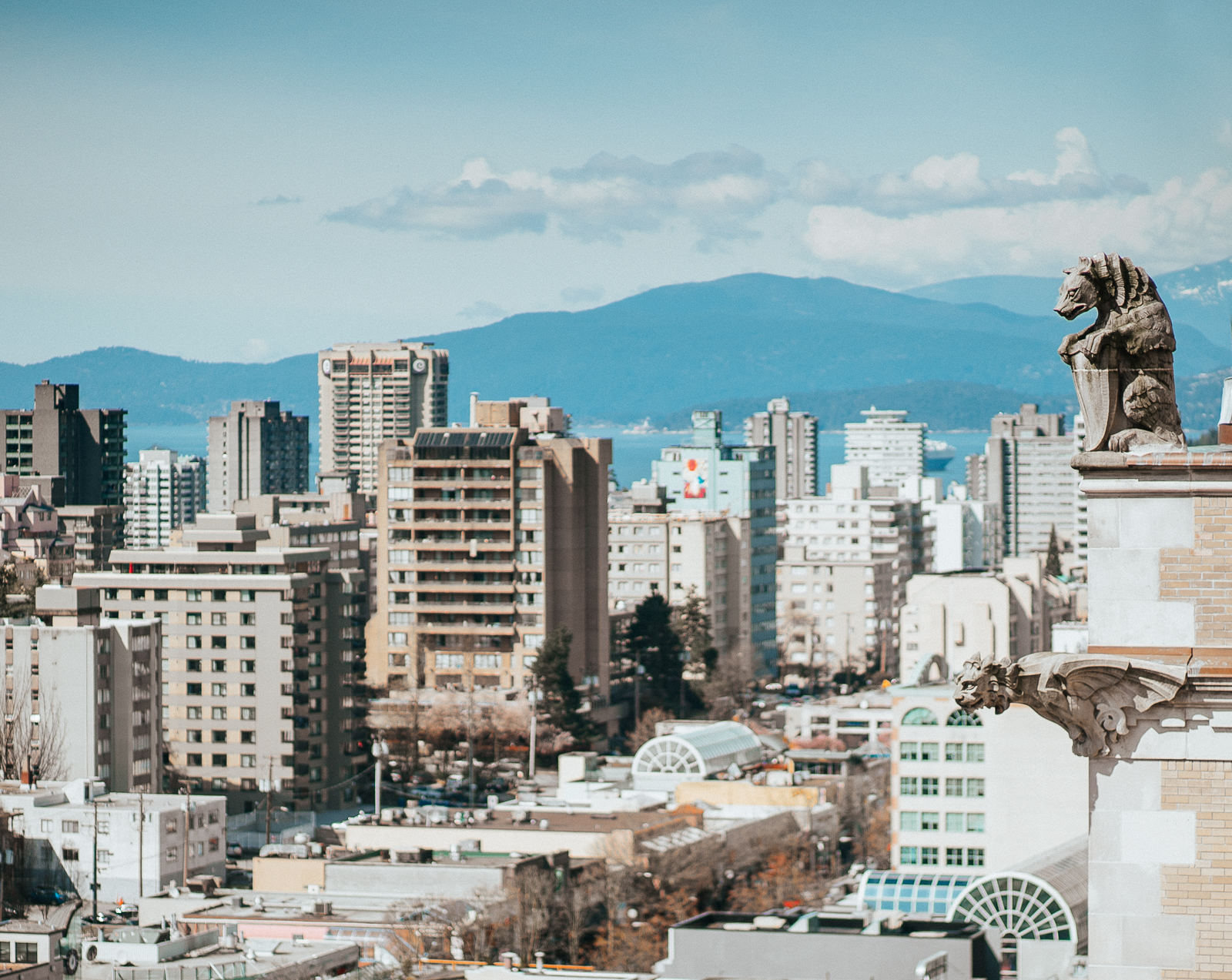 View of city from rooftop of Fairmont Hotel Vancouver with gargoyle