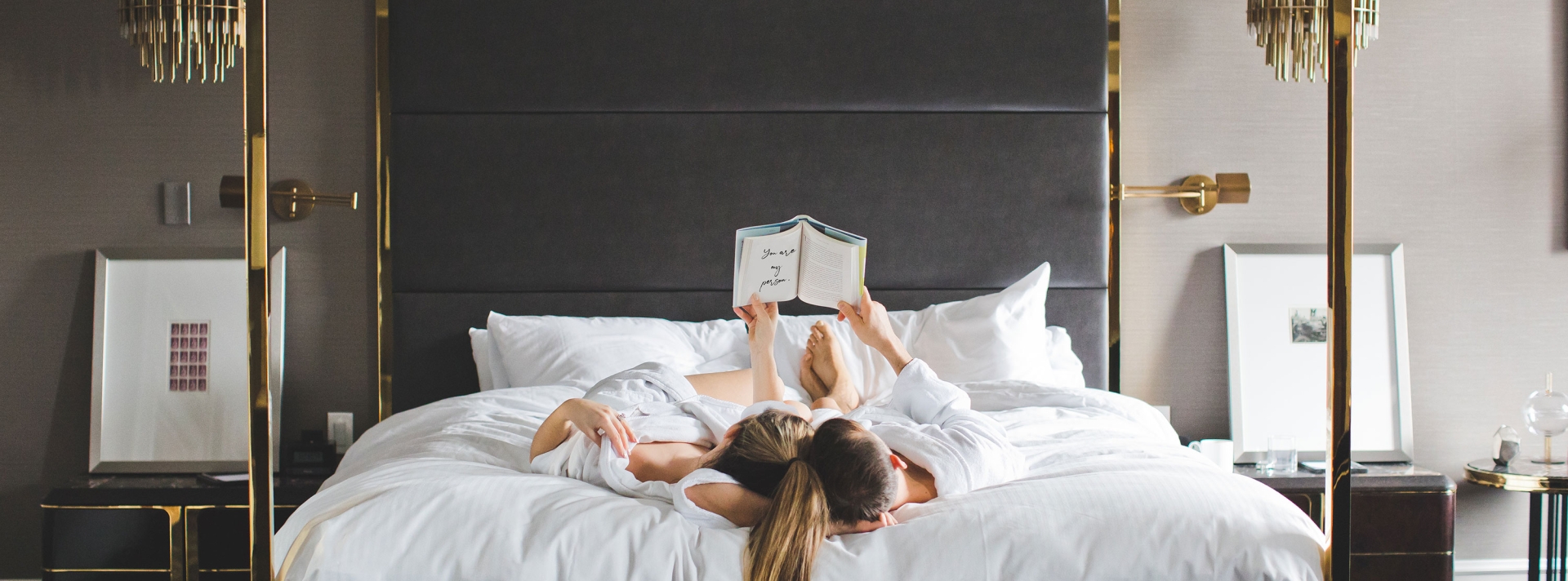 Romantic photo of couple reading together and relaxing in bed in suite at Fairmont Hotel Vancouver | Image by Ashley Ferreira Dragonflight Photography
