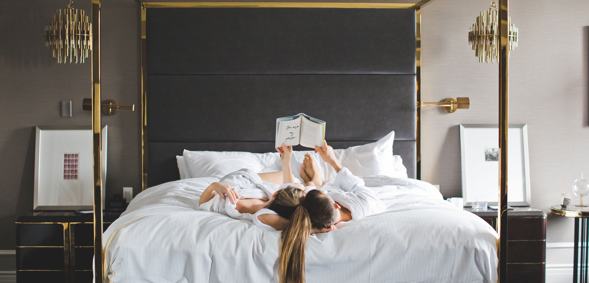 Romantic photo of couple reading together and relaxing in bed in suite at Fairmont Hotel Vancouver | Image by Ashley Ferreira Dragonflight Photography